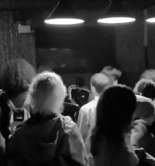 Audience watching cash perform live with egoseed at Relax, New York, photographed in black and white.