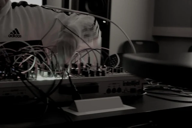 Modular synthesizer and patch cables on a studio desk.